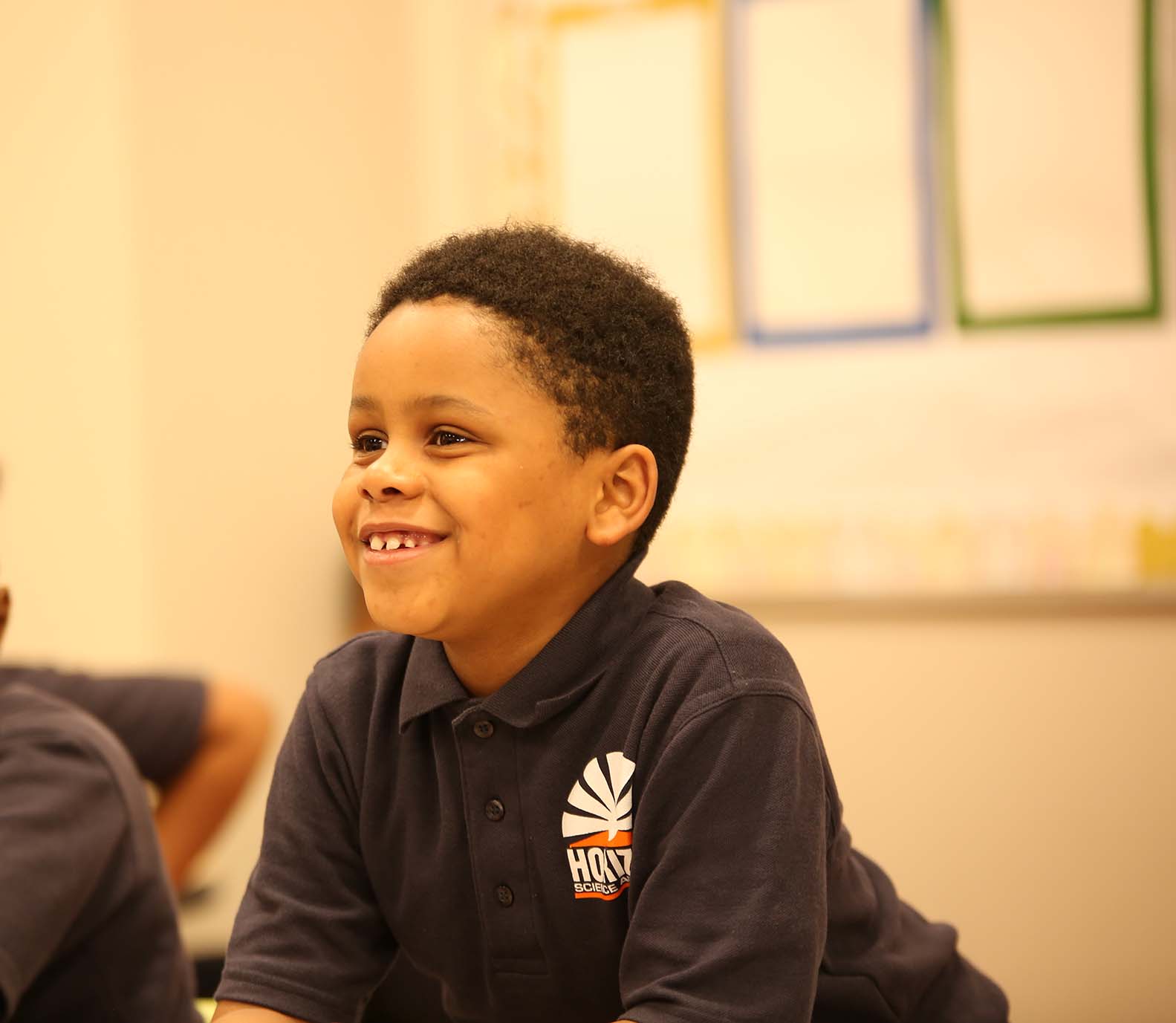 HSA Columbus Primary student wearing headphones uses a laptop in class